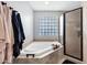 Close up shot of soaking tub, glass block window, and separate shower at 8034 E Del Caverna Dr, Scottsdale, AZ 85258