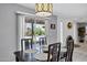 Bright dining area features a dark wood table, modern light fixture, and sliding glass doors to the pool at 8034 E Del Caverna Dr, Scottsdale, AZ 85258