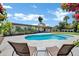Inviting pool area with lounge chairs, palm trees, and blooming flowers, creating a serene outdoor oasis at 8034 E Del Caverna Dr, Scottsdale, AZ 85258
