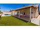 This backyard features a covered patio, a pool, and artificial grass at 8500 W Saint John Rd, Peoria, AZ 85382