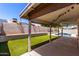 This backyard features a covered patio, a pool, artificial grass, and a block wall at 8500 W Saint John Rd, Peoria, AZ 85382