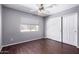 This bedroom features a ceiling fan, a window with blinds, and a closet with sliding doors at 8500 W Saint John Rd, Peoria, AZ 85382