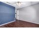 The bedroom has a blue accent wall, a ceiling fan, and a door leading to another room at 8500 W Saint John Rd, Peoria, AZ 85382