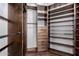 Well-organized walk-in closet with shelving, wooden drawers, and wood floors at 8500 W Saint John Rd, Peoria, AZ 85382