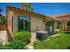 Back exterior showcasing large windows, a well-maintained AC unit, and lush, green landscaping at 9575 S Ash Ave, Tempe, AZ 85284