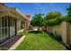 Lush backyard with a covered patio, green lawn, and privacy fencing, perfect for outdoor enjoyment at 9575 S Ash Ave, Tempe, AZ 85284
