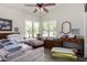 Bright bedroom with light walls, ceiling fan, shuttered windows and wood-style flooring at 9575 S Ash Ave, Tempe, AZ 85284