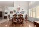 Charming dining room offers vaulted ceilings, wood floors, and a decorative collection of wall art at 9575 S Ash Ave, Tempe, AZ 85284