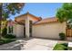 Beautiful home featuring a two-car garage, tiled roof, arched entry, and verdant landscaping at 9575 S Ash Ave, Tempe, AZ 85284