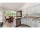 Kitchen/Breakfast nook features stainless steel dishwasher, white cabinets, and views to the outside at 9575 S Ash Ave, Tempe, AZ 85284