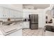 Well-lit kitchen showcasing stainless steel refrigerator, white cabinets, and neutral countertops at 9575 S Ash Ave, Tempe, AZ 85284