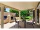 Covered patio featuring a built-in fireplace, outdoor seating, and serene views of the landscaped backyard at 9575 S Ash Ave, Tempe, AZ 85284