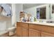 Cluttered bathroom featuring a wood vanity with an off-white sink, and a toilet beside an open shower stall at 980 W Prior Ave, Coolidge, AZ 85128