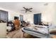 A disheveled bedroom features a ceiling fan, a dresser with a TV, and a bed with a wolf-themed blanket at 980 W Prior Ave, Coolidge, AZ 85128