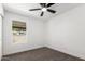 This bedroom features a ceiling fan, neutral carpeting, and a window bringing in natural light at 9855 S 47Th Pl, Phoenix, AZ 85044