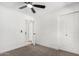 A bright bedroom with neutral carpet features an open door, a ceiling fan, and closet space at 9855 S 47Th Pl, Phoenix, AZ 85044