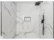 Walk-in shower featuring marble style tile, black fixtures, and recessed shelf at 9855 S 47Th Pl, Phoenix, AZ 85044