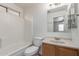 Bathroom showcasing a bathtub with tile, single sink vanity and a large mirror at 11139 W Devonshire Ave, Phoenix, AZ 85037