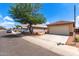 Single-Gathering home with a spacious two-car garage and desert landscaping with a tree providing shade at 11139 W Devonshire Ave, Phoenix, AZ 85037
