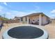Expansive backyard with a trampoline, fire pit area, and a covered patio with outdoor seating at 11159 E Sebring Ave, Mesa, AZ 85212