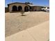 Single-story home with a low-maintenance desert-scape front yard and tan exterior with arched window detailing at 11640 N 74Th Dr, Peoria, AZ 85345