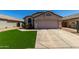 Charming single-story home with a neutral color palette, well-manicured lawn, and two-car garage at 15231 W Melissa Ln, Surprise, AZ 85374