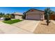 Single-story home with a two-car garage, desert landscaping, artificial turf, and a spacious driveway at 15231 W Melissa Ln, Surprise, AZ 85374