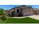 One-story home with desert landscaping, artificial turf, two-car garage, and a charming front facade at 15231 W Melissa Ln, Surprise, AZ 85374