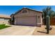 Single-story home with a desert landscape, two-car garage, and a mature saguaro cactus at 15231 W Melissa Ln, Surprise, AZ 85374