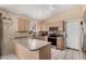 Bright kitchen area features well-lit cabinets, sleek countertops, and modern appliances at 15231 W Melissa Ln, Surprise, AZ 85374