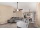 Inviting living room with neutral paint, ceiling fan, carpet flooring, and a comfortable gray sectional sofa at 15231 W Melissa Ln, Surprise, AZ 85374