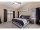 Main bedroom features a modern bed, with bright windows and black curtains at 15231 W Melissa Ln, Surprise, AZ 85374