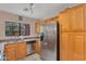 Bright kitchen with stainless steel refrigerator and view to landscaped yard at 154 W Hayden Park Rd, San Tan Valley, AZ 85143