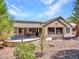 Backyard features a covered patio and desert landscaping including palm trees and shrubs at 15539 W La Salinas Ln, Surprise, AZ 85374