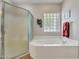 Relaxing bath with walk-in shower, soaking tub and glass block window at 15539 W La Salinas Ln, Surprise, AZ 85374