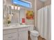 Bright bathroom features white cabinets, a decorative mirror, and a shower with curtain at 15539 W La Salinas Ln, Surprise, AZ 85374
