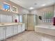 Bright bathroom featuring double sinks, a walk-in shower, and a soaking tub at 15539 W La Salinas Ln, Surprise, AZ 85374