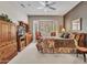 Bedroom showcases a bay window, ceiling fan, and natural wood furniture at 15539 W La Salinas Ln, Surprise, AZ 85374