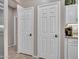 Hallway featuring white doors, tile floor, and bright lighting at 15539 W La Salinas Ln, Surprise, AZ 85374