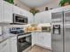 Bright kitchen featuring stainless steel appliances, white cabinets, and decor accents at 15539 W La Salinas Ln, Surprise, AZ 85374