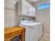 Functional laundry room with white cabinets and a washer and dryer at 15539 W La Salinas Ln, Surprise, AZ 85374