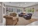 Cozy living room with neutral carpet, plantation shutters, and abundant natural light at 15539 W La Salinas Ln, Surprise, AZ 85374