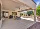 This covered patio has ceiling fans, a seating area, and a grill for outdoor entertainment at 15539 W La Salinas Ln, Surprise, AZ 85374