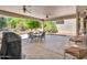Relax on the covered patio, which includes a ceiling fan and dining area at 15539 W La Salinas Ln, Surprise, AZ 85374