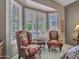 Bedroom sitting area with plantation shutters offers natural light, views, and comfortable chairs at 15539 W La Salinas Ln, Surprise, AZ 85374