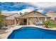 The backyard features a pool, a patio, lounge chairs, and lush landscaping at 1707 W Stanford Ave, Gilbert, AZ 85233