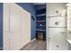 Bathroom featuring tiled shower, shelving niche, and white double door closet at 1707 W Stanford Ave, Gilbert, AZ 85233