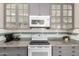Well-equipped kitchen featuring modern appliances, gray cabinetry, a tile backsplash, and ample countertop space at 1707 W Stanford Ave, Gilbert, AZ 85233