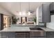 Open concept kitchen with granite countertops, breakfast bar, stainless steel sink, and modern appliances at 1707 W Stanford Ave, Gilbert, AZ 85233