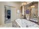 Relaxing bathroom with jacuzzi tub, glass-enclosed shower, and access to walk-in closet at 18036 W San Miguel Ave, Litchfield Park, AZ 85340